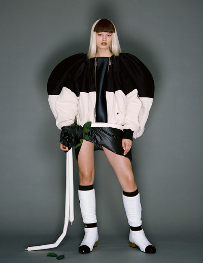 Britt wears jacket by Louis Vuitton, skirt by Moncler, and boots by Chanel. - © System Magazine