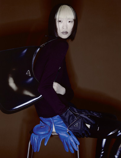 Chu wears jumper, boots and bag by Prada, with belt made with gloves by Prada. - © System Magazine