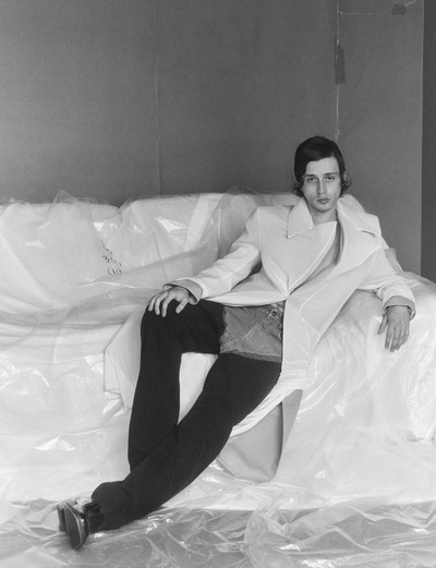Lorenzo wears white jacket, black and blue cut-out jeans, and loafers by Y/Project Spring/Summer 2019 - © System Magazine