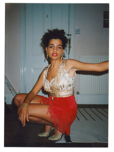 1990. ‘Michelle posing in her bedroom. Both the gold top and red leather skirt were made by Phyliss, the local tailor in Wimbledon, based on pages from *Vogue* that Michelle gave her.’ Michelle: ‘But I did all the embellishment by hand – it took me *ages*.’ - © System Magazine