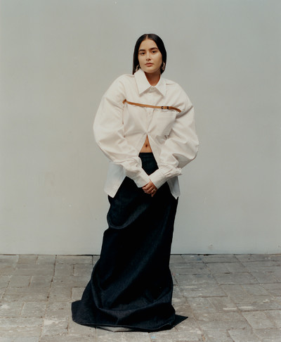 Sabrina Arroyave, junior designer at Luar, wears boulder-shoulder belted button-up dress and runway denim tube skirt, both by Luar. - © System Magazine