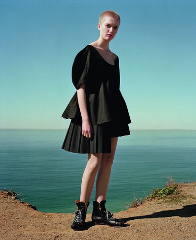 Black cotton puff-sleeve top by Céline
Black pleated skirt with hip bustle by Julien David
Black croc flat-toed lace-up ankle boots from John Moore at The Old Curiosity Shop
White pearl-drop earring by Aurélie Bidermann - © System Magazine