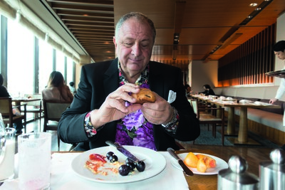 Jean Pigozzi wearing an XXXL bespoke black wool Dior Homme suit, made by Kris Van Assche, and his own shirt. ‘Pain au chocolat for breakfast with Cary Leitzes at The Shilla Hotel in Seoul, South Korea.’ - © System Magazine